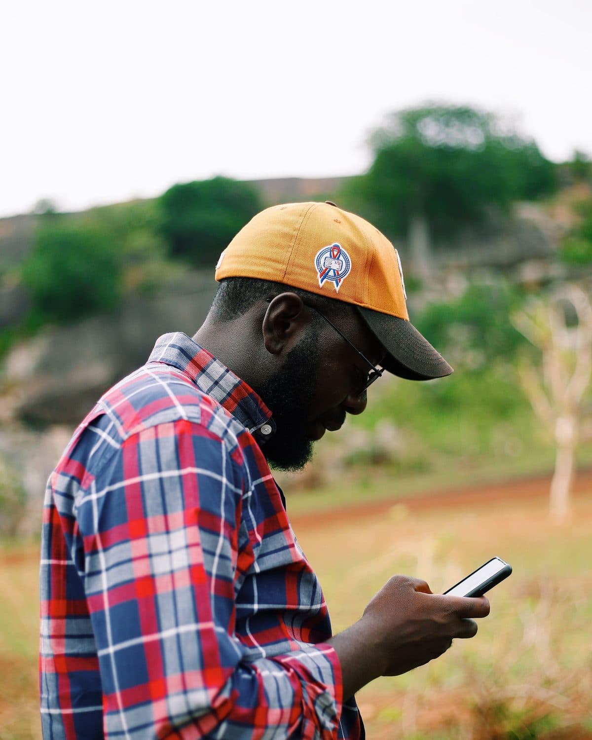 Out in the countryside, a man checks his phone.